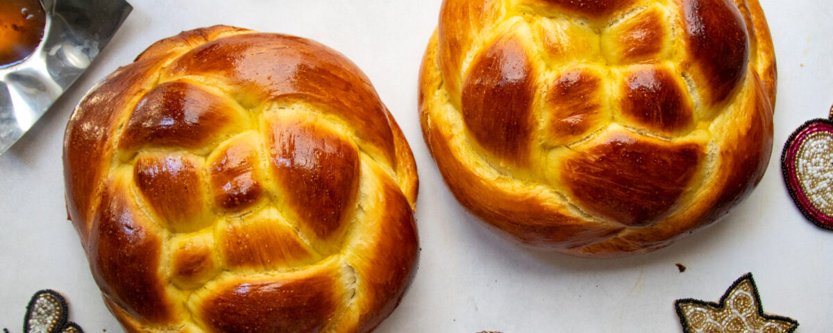 Two woven round challah loaves for Rosh Hashanah with apples and honey