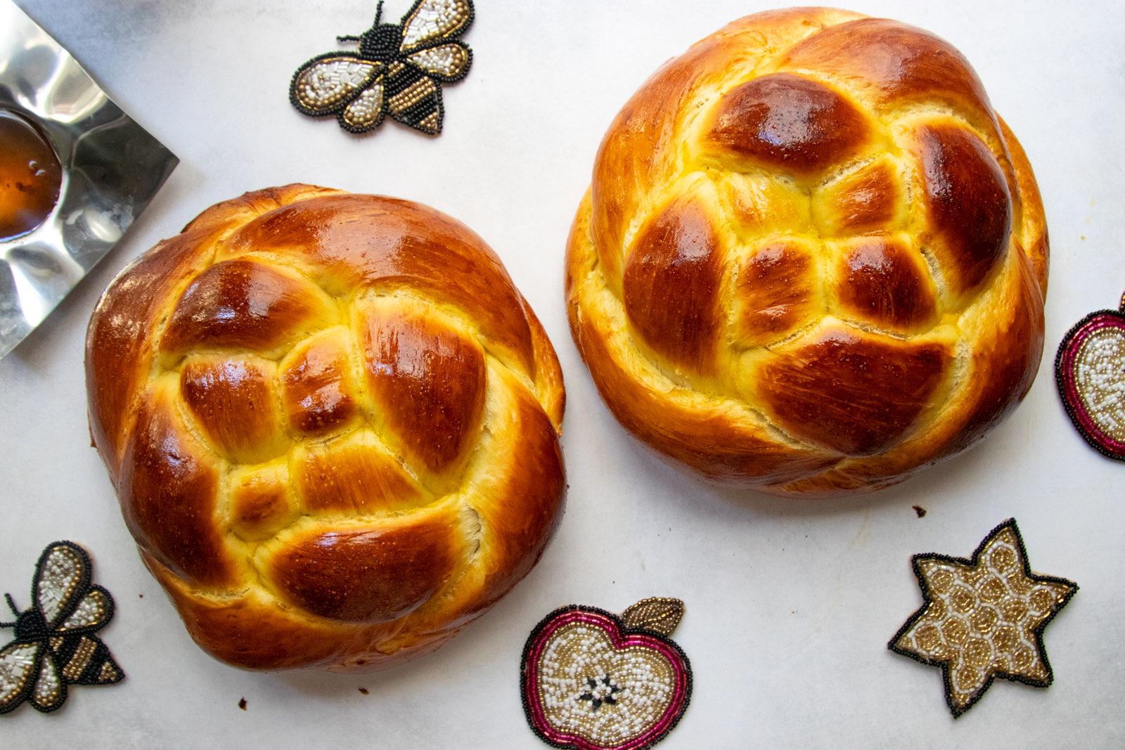 Two woven round challah loaves for Rosh Hashanah with apples and honey