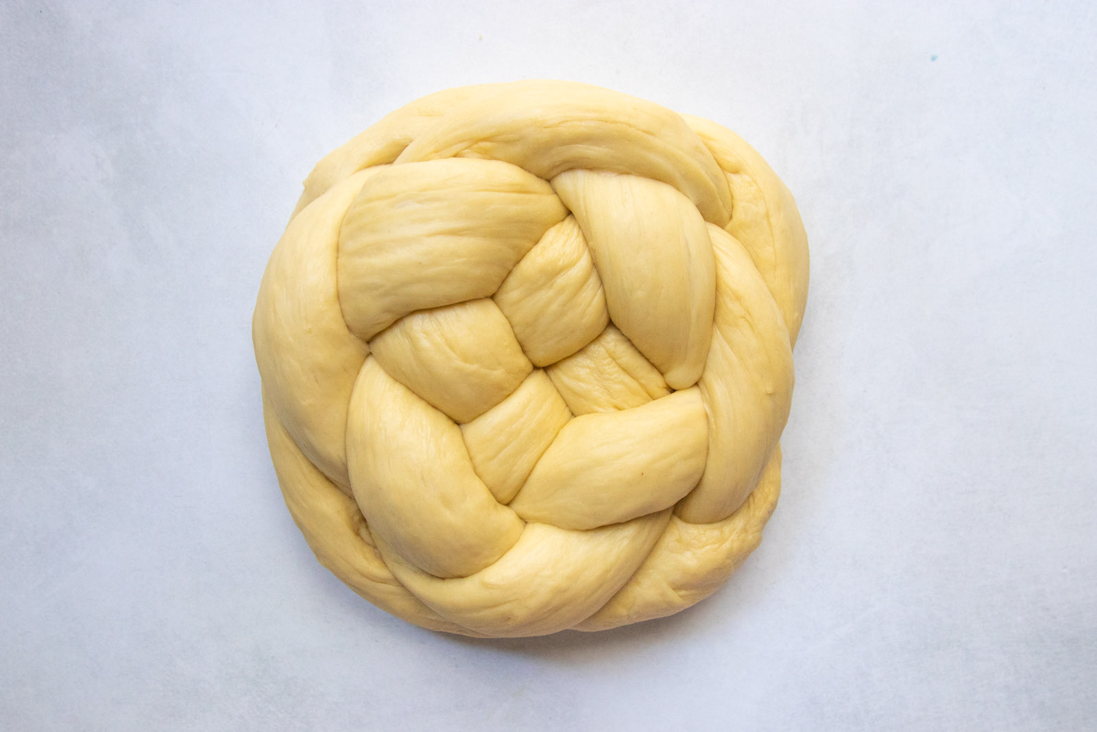 Tucking the ends of the round challah underneath the loaf