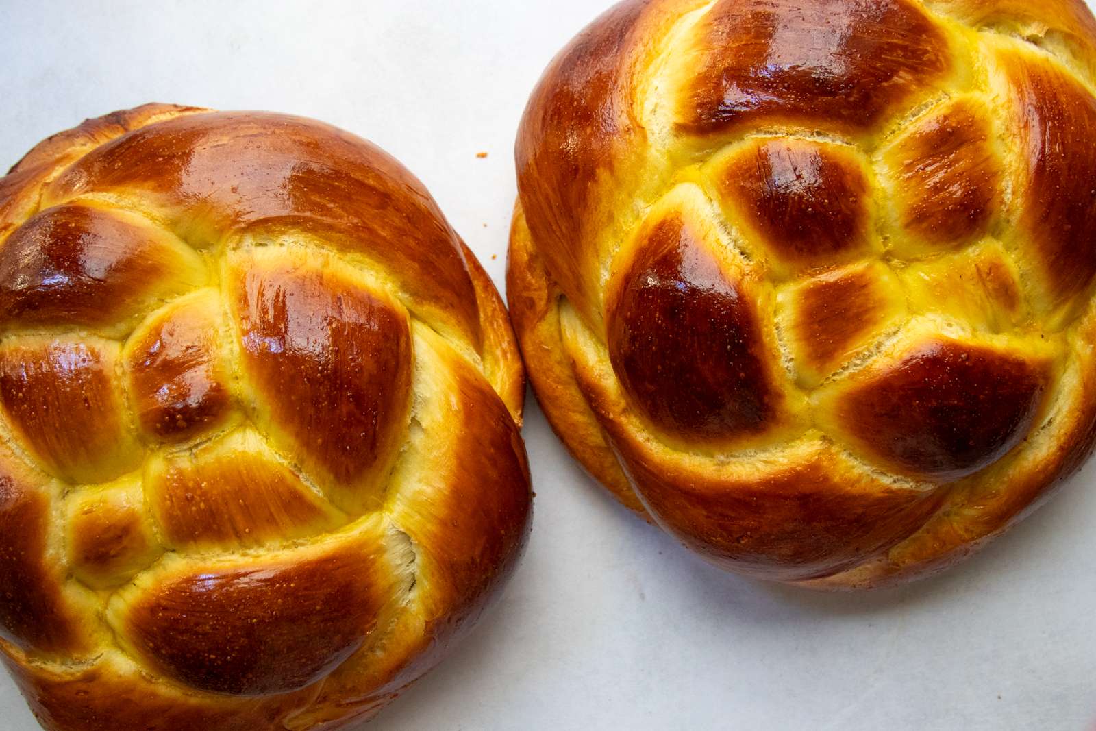 Two woven round challah loaves side by side for Rosh Hashanah
